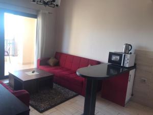 a living room with a red couch and a table at Aldau Heights in Hurghada