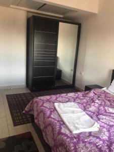 een slaapkamer met een paars bed en een spiegel bij Aldau Heights in Hurghada