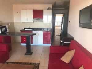 een woonkamer met een rode bank en een keuken bij Aldau Heights in Hurghada