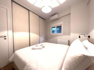 una camera con 2 letti bianchi e uno specchio di 2-Bed Gem in Serene Locale ad Atene