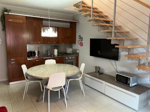 uma cozinha e sala de jantar com uma mesa e uma escada em La Darsena apartment em Peschiera del Garda
