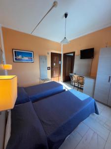 a bedroom with a blue bed and a kitchen at Hotel L'Approdo in Brindisi