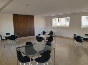 une chambre avec des tables et des chaises dans un bâtiment dans l'établissement Apartamento em Ponta de Campina a 600m da praia, à Cabedelo