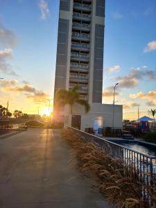un grand bâtiment avec un palmier devant lui dans l'établissement Apartamento em Ponta de Campina a 600m da praia, à Cabedelo