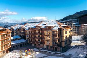 a group of buildings with snow on the roofs at Beautiful Apartment in Bansko