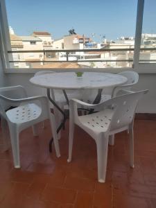 a white table and two chairs and a table and a window at La Carihuela in Torremolinos