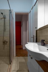 La salle de bains est pourvue d'un lavabo blanc et d'une douche. dans l'établissement Stylish and Central 2BR Flat In The Heart Of Sisli, à Istanbul