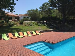 a row of lounge chairs next to a swimming pool at Casa das Xaras in Sintra