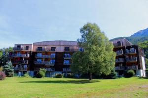 een groot gebouw met een boom ervoor bij LA Source Blanche in Saint-Jean