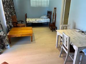 una sala de estar con mesas y sillas de madera. en INTERPRO, en Bloemfontein