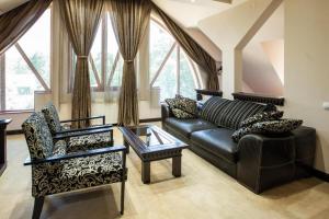 a living room with a leather couch and a chair at Hotel Vila Lago in Palić