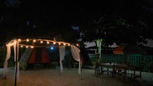 a tent and a table with lights at night at SHALOM CAMP in El Nido