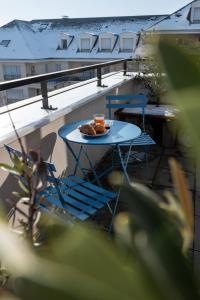 une table avec une assiette de nourriture sur un balcon dans l'établissement Le reflet de la Seine - balcon - 2 chambres - RER A, à Carrières-sous-Poissy
