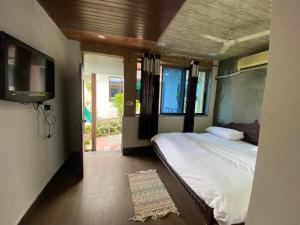 マウント・アブにあるRudraksha Innのベッドルーム(ベッド1台、薄型テレビ付)