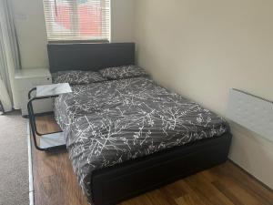 a bed in a bedroom with a black bed frame at Modern Studio in Rayners Lane Pinner Harrow near wembley Greater London in Pinner