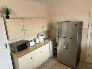 a kitchen with a refrigerator and a microwave at Lighthouse Villa in Cape St Francis