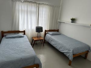 two twin beds in a room with a window at Lighthouse Villa in Cape St Francis