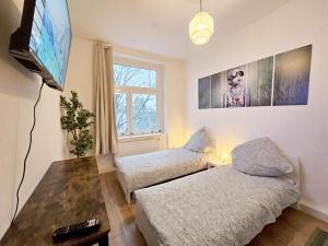 een woonkamer met een bank en een flatscreen-tv bij Nice Apartment in Wuppertal in Wuppertal