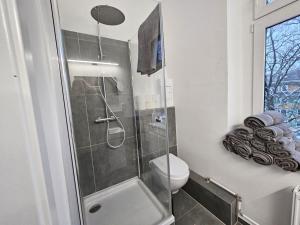 een badkamer met een toilet en een glazen douche bij Nice Apartment in Wuppertal in Wuppertal