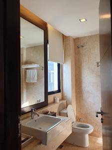 a bathroom with a sink and a toilet and a mirror at Avani Sepang Goldcoast Resort Family Villa in Bagan Lalang