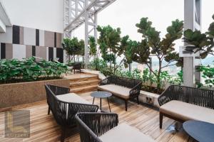 een restaurant met stoelen, tafels en planten bij Colony Chow Kit Guesthouse in Kuala Lumpur