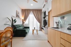 een keuken en een woonkamer met een groene bank bij Colony Chow Kit Guesthouse in Kuala Lumpur +4 foto's