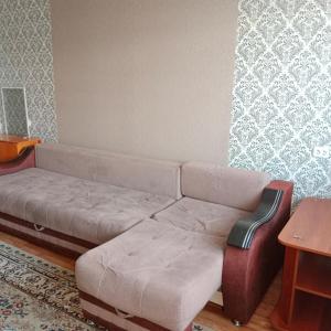 un soggiorno con divano e sedia di Темиртау 7 микрорайон 1а a Temirtaū
