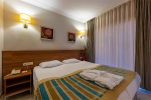 Una habitación de hotel con una cama con toallas. en Viking Express Hotel, en Kemer