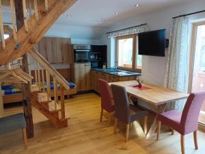 a kitchen and dining room with a wooden table and chairs at Chalet Leni in Schladming