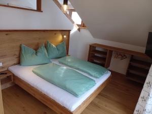a bed with green pillows in a room at Chalet Leni in Schladming