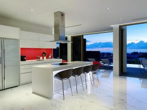 a kitchen with a white counter and stools at Designer Panoramic Seaview 2br Pool Villa Naithon Beach num7131 in Nai Thon Beach