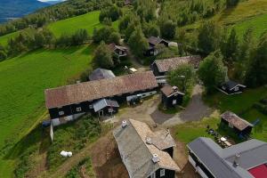 an aerial view of a house in a green field at Sjarmerende tømmerhytte på gårdstun 