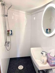 a white bathroom with a sink and a mirror at Sjarmerende tømmerhytte på gårdstun in Baukål +24 photos