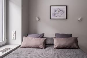 une chambre avec un lit avec deux oreillers dans l'établissement Dzintaru Beachside 1BR Apartment With Courtyard View, Walk to Nature & Sea, à Jurmala