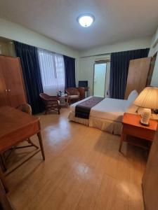 une chambre d'hôtel avec un lit et une table dans l'établissement 12PM Bangkok, à Bang Kapi