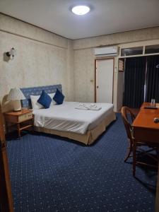 a bedroom with a bed with blue pillows and a desk at 12PM Bangkok in Bang Kapi