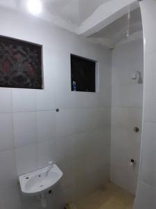 La salle de bains blanche est pourvue d'un lavabo et d'une fenêtre. dans l'établissement Sasha Holiday Apartments #B5, à Mtwapa