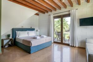 a bedroom with a bed and a sliding glass door at Ageras Santa Marina in Lefkada