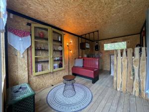salon z czerwoną kanapą i stołem w obiekcie Le Cabanon w mieście Dangeau +16 zdjęć