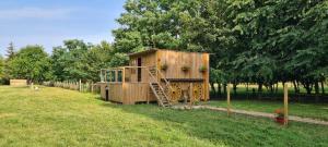 a wooden play house in the grass in a field at Le Cabanon in Dangeau