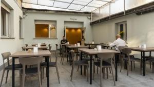 zwei Männer sitzen an Tischen in einem Restaurant in der Unterkunft Hotel Rex Milano in Mailand