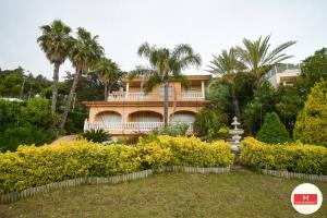 una grande casa con palme e un giardino di Villa Cerca Del Mar num1125 a Blanes