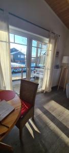 a living room with a table and a chair and a window at Haus Nordwind in Bedekaspel