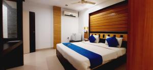 a bedroom with a large bed with a wooden headboard at Hotel Franklein Stay At Delhi Airport in New Delhi