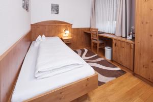 Schlafzimmer mit einem Bett, einem Schreibtisch und einem Stuhl in der Unterkunft Hotel Zu den Drei Kronen in Donauwörth