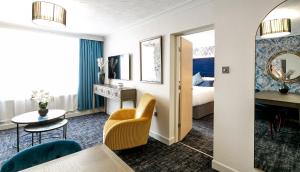 um quarto de hotel com uma cama, uma mesa e cadeiras em Cedar Court Hotel Huddersfield em Huddersfield