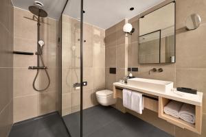 a bathroom with a shower and a sink and a toilet at Hotel Ambasador in Split
