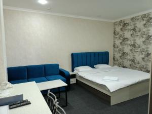 a room with two beds and a blue couch at ЭДЕМ in Taraz