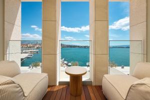 a room with two chairs and a view of the water at Hotel Ambasador in Split