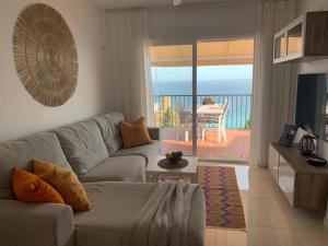 ein Wohnzimmer mit einem Sofa und Meerblick in der Unterkunft Frontline Nerja-Torrox Costa - Ladera del mar 2 in Torrox Costa